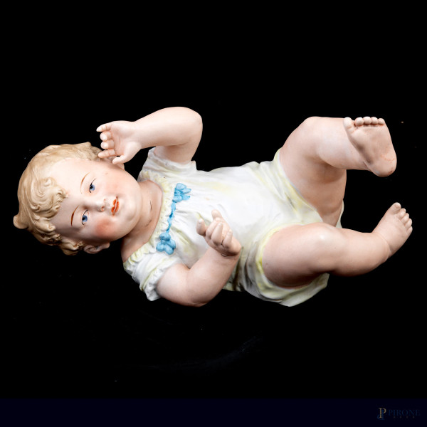Scultura in bisquit policromo raffigurante bambino, XX secolo, cm 13,5x24x11, (segni di usura,  difetti)