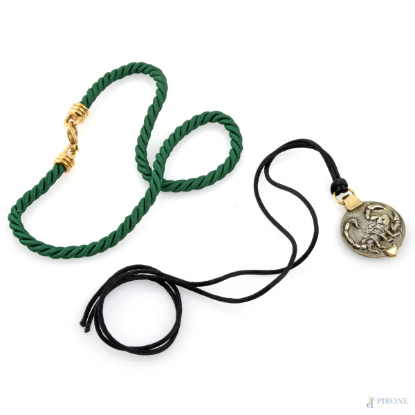 Lotto composto da cordoncino verde con chiusura in oro e da ciondolo in oro e argento con scorpione, peso complessivo lordo gr 32