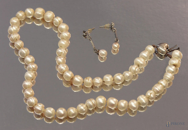 Parure composta da collana e coppia di orecchini di perle vere coltivate con chiusura in argento a forma di cuore.
