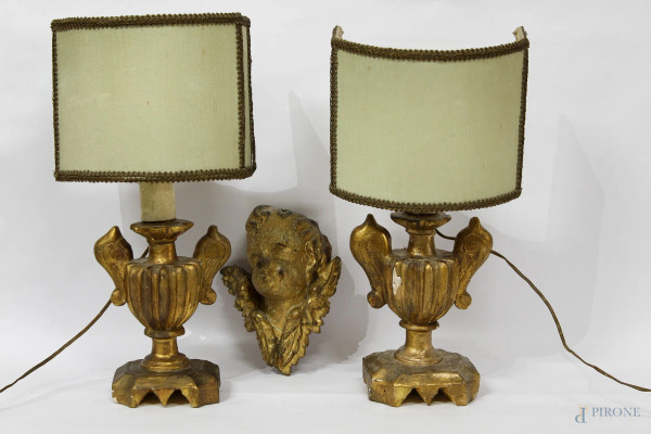 Lotto composto da una testina di angioletto in legno dorato, XVIII sec., H 19 cm, e da due lampade in legno dorato, XIX sec., H 26 cm.