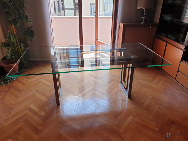 Tavolo di linea rettangolare, XX secolo, piano in cristallo poggiante su struttura in acciaio,  cm h 73,5x102,5x99,5,  (piccola sbeccatura al piano).