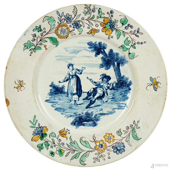 Piatto in ceramica, decoro centrale raffigurante popolana e gentiluomo, tesa a motivi floreali policromi, diam. cm 24,5, XVIII secolo, (sbeccature).