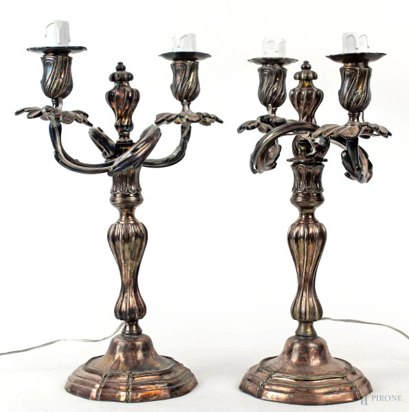 Coppia di candelabri in metallo argentato stile Luigi XV, a due fiamme con braccia a ramages, fusto torchon poggiante su base mistilinea, cm h 37,5, (difetti)