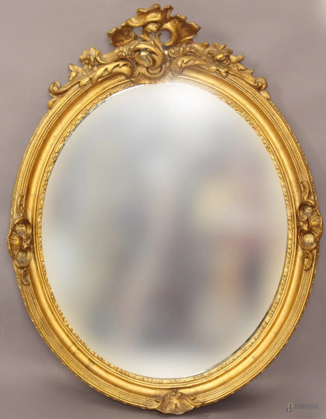 Specchiera di linea ovale in legno intagliato e dorato, Francia XIX sec, h. 79x61 cm.