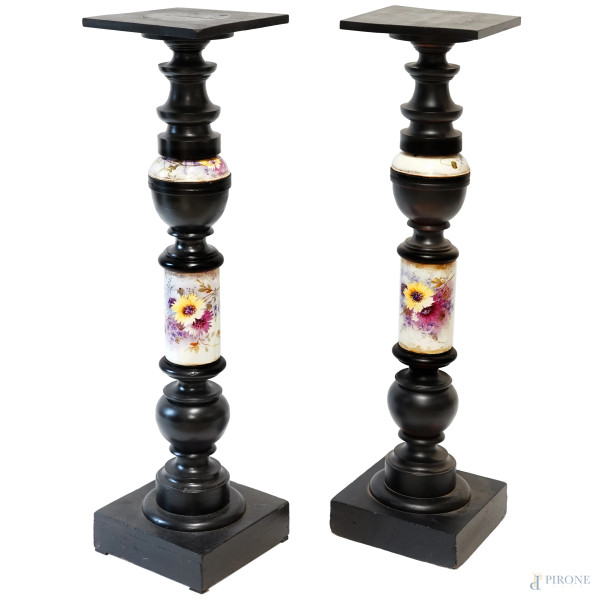 Coppia di piedistalli a forma di colonna in legno laccato nero e porcellana policroma con decori floreali, XX secolo, altezza cm 106,5 (difetti)