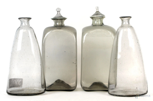 Lotto di quattro bottiglie in vetro, alt. max cm 29, XX secolo,  (difetti e due tappi mancanti).
