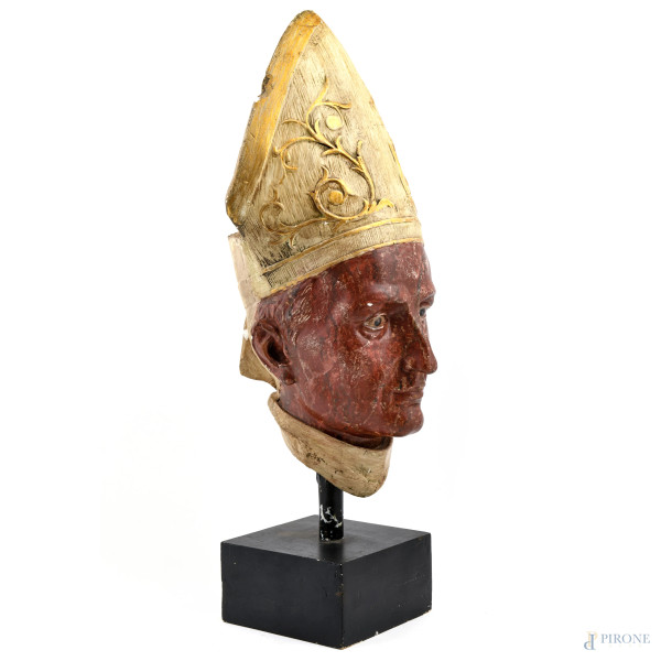 Testa di vescovo, XX secolo, scultura in gesso dipinto e dorato poggiante su base in legno dipint...