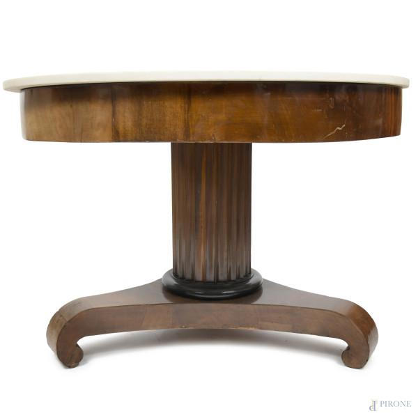 Tavolo tondo in noce con piano in marmo, fusto a colonna scanalata poggiante su base con tre este...