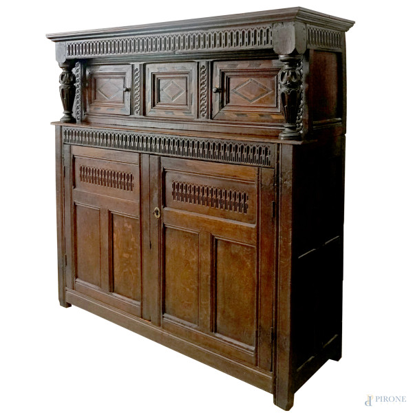 Mobile credenza inglese in rovere, parte inferiore a due sportelli con decori intagliati, parte superiore a due sportelli e un pannello centrale fisso con intarsi in varie essenze, supporti a balaustro torniti su ciascuna estremità, XIX secolo, cm 162x149x49,5 (difetti)