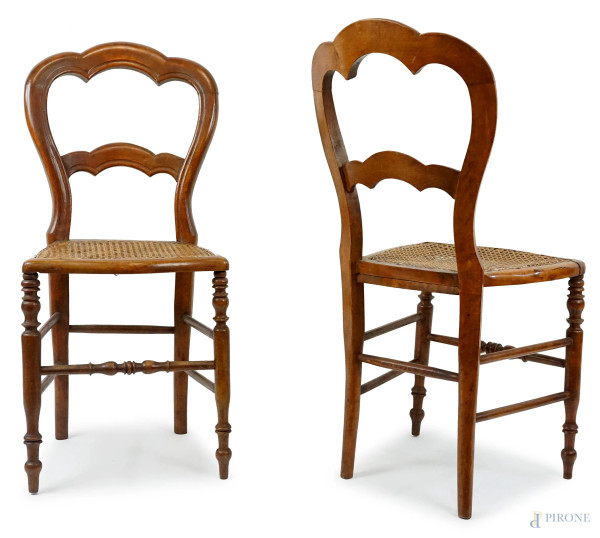 Due sedie in noce, fine XIX secolo, schienali a giorno, seduta in paglia di Vienna, gambe anteriori tornite, le posteriori lievemente a sciabola, cm h 89, (difetti).