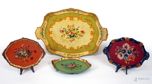 Lotto di quattro vassoi di linea sagomata in legno dorato e dipinto in policromia, misure max cm 42x59, epoche diverse, (difetti e cadute di colore).