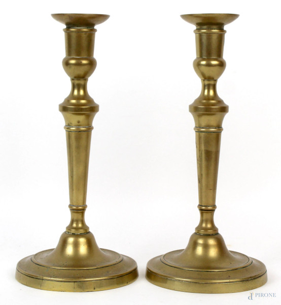Coppia di candelieri in bronzo dorato, con fusto e base lisci, cm h 26.