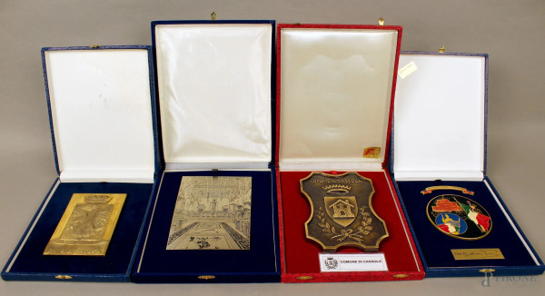 Lotto composto da quattro placche commemorative in materiali diversi, entro astucci.