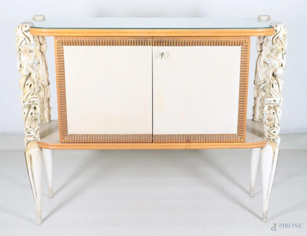 Credenza buffet "La permanente Mobili Cantù" in legno intagliato e laccato avorio con piano in vetro opaline e doppia anta rivestita in pergamena, anni Quaranta-Cinquanta, cm  117x139x44, (segni di usura)