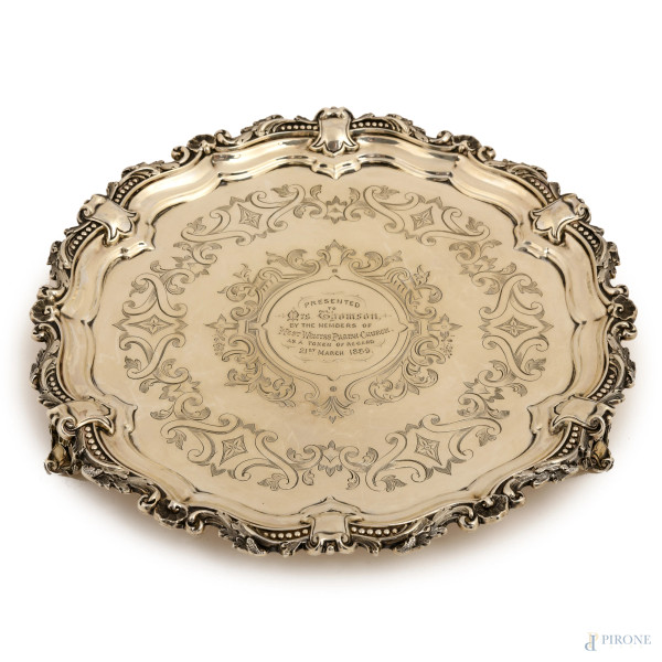 Salver a profilo mosso in argento cesellato e inciso con iscrizione centrale, poggiante su quattro piedini. Inghilterra, 1889, peso gr 450, diametro cm 24