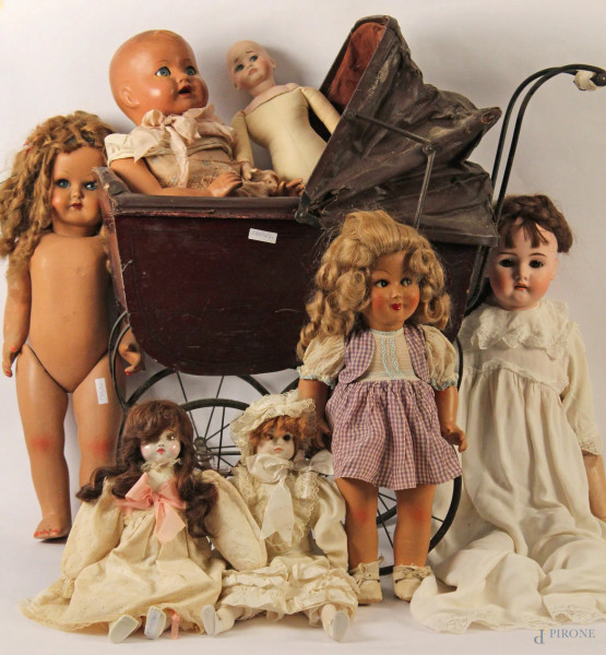 Lotto di sette antiche bambole ed una corrozzina 
