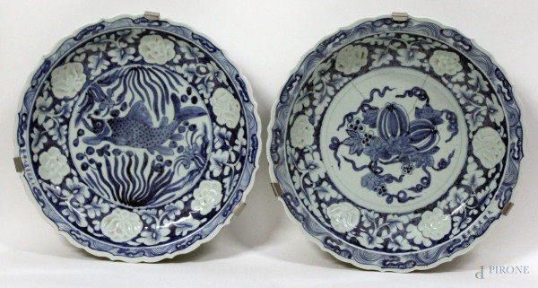 Lotto composto da due piatti da muro in porcellana bianca e blu a decoro di fiori e carpa, firmati, Arte Orientale, diametro 40 cm.