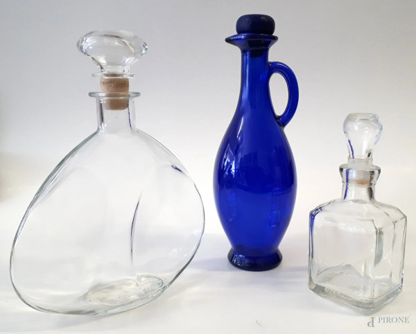 Lotto composto da tre bottiglie, una in vetro blu design stile Monica Bratt Wijkander, e due in cristallo trasparente, varie dimensioni e fogge, altezza massima cm 26