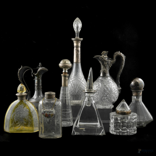 Lotto di 7 bottiglie in vetro e due caraffe con inserti in argento, XX secolo, altezza massima cm 41,5, (segni di usura, difetti)