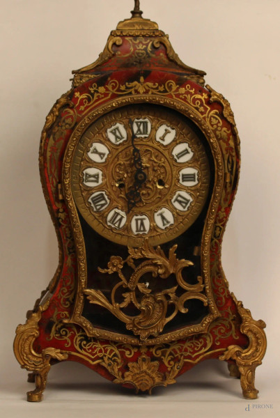 Orologio di linea Boulle con intarsi in ottone, finiture in bronzo cesellato e dorato.