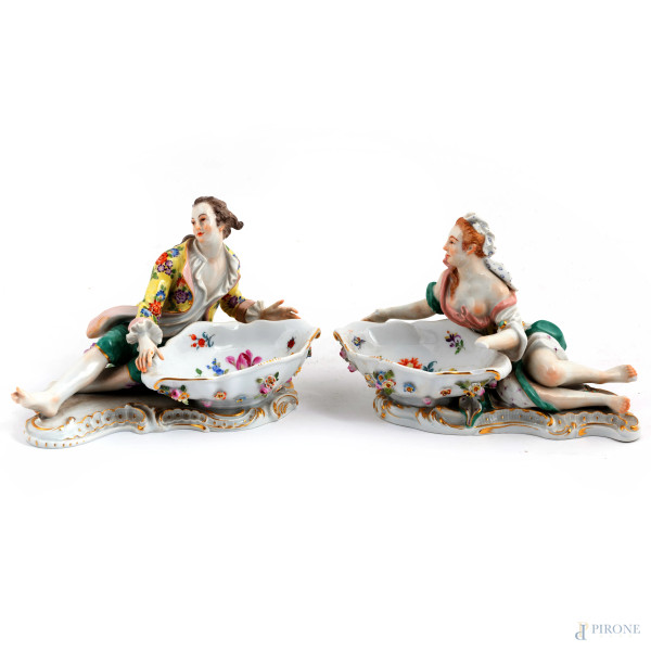 Coppia di saliere in porcellana Meissen decorate in policromia con figura maschile e femminile, XIX-XX secolo, misure massime cm  11,5x20x13,5, (felature, rotture, restauri, difetti)