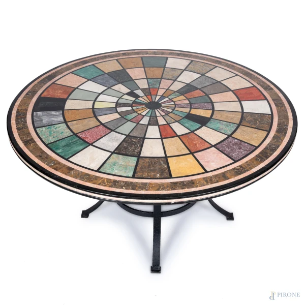 Tavolo tondo  con struttura in ferro battuto e piano in legno rivestito in commesso di  marmi policromi, XX secolo, altezza cm 76, diametro piano cm 138, (segni di usura)