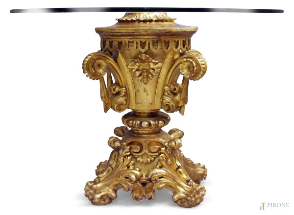 Tavolo in cristallo poggiante su base in legno intagliato e dorato a motivi di foglie d&#39;acanto retta da quattro piedi zoomorfi, H 77 cm, diam. 110 cm, XVIII sec.