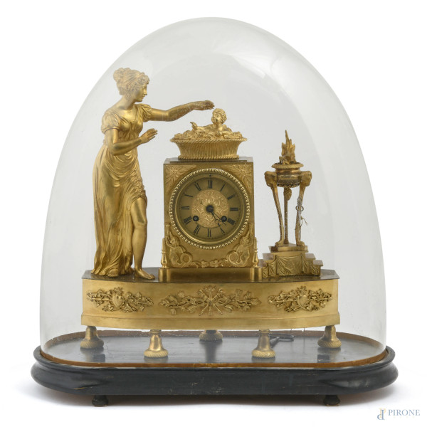 Orologio in bronzo dorato con fanciulla ed amorino. Quadrante a smalto in numeri romani. Entro campana in vetro su base in legno, XIX-XX secolo, cm 48x44x22,  (segni di usura, difetti, da revisionare)