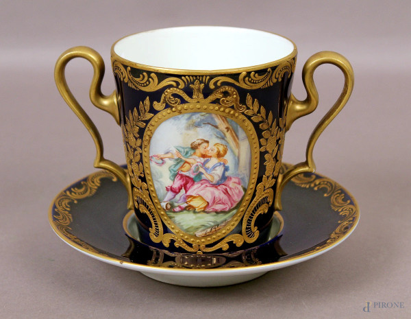 Tazza con piattino in porcellana dipinta con medaglione centrale raffigurante scena galante, particolari dorati, marcata, XIX sec., H 10,5 cm.