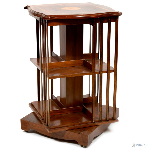 Libreria girevole in legno di mogano con piano ad intarsio centrale e profilo mosso. XX secolo, cm 81x50x50, (difetti)