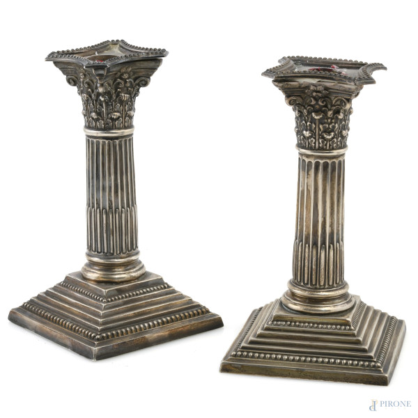 Coppia di candelieri rivestiti in argento, XX secolo, altezza cm 15,5, peso lordo complessivo gr 970, (segni di usura)