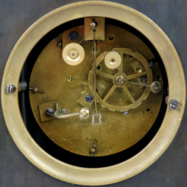 Pendola da tavolo in metallo brunito e dorato, XX secolo, quadrante affiancato da figura alata co...