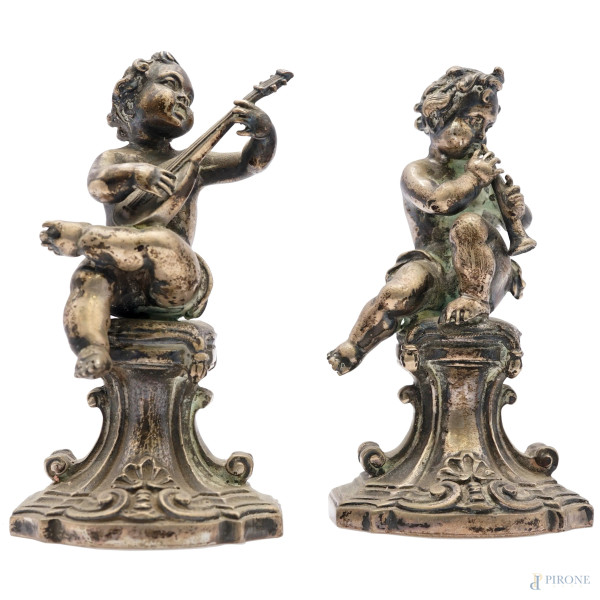 Coppia di putti musicanti in argento cesellato, manifattura italiana, seconda metà del XX secolo, cm h 9, peso gr 442