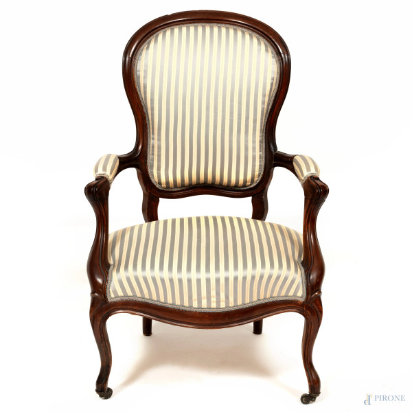 Poltrona in legno intagliato con seduta, schienale  e braccioli imbottiti e rivestiti in tessuto a righe celesti, XX secolo, cm 99,5x63,5x63,5, (segni di usura, scalfiture, difetti)