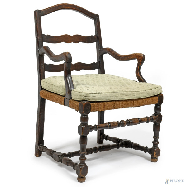 Poltrona in noce con gambe tornite raccordate da traverse e braccioli e schienale sagomati. Seduta in corda, XX secolo, cm 96x60x60, (segni di usura, fori di tarlo, difetti)