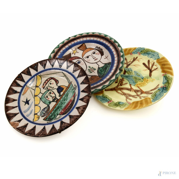 Lotto di tre piatti in maiolica decorata in policromia di varia manifattura, XX secolo, diametro massimo cm 20, (segni di usura, scalfiture, difetti, sbeccature, rotture)