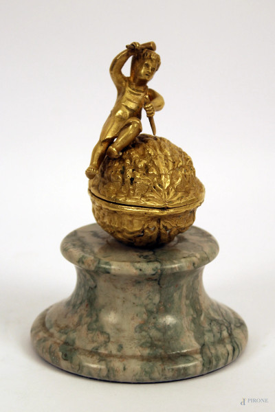 Cofanetto a forma di noce sormontato da fanciullo in bronzo dorato, base in marmo, XX sec., h. cm 16.