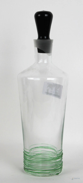 Bottiglia in vetro trasparente decorata alla base con fili in vetro verde e tappo nero, altezza cm 36, XX secolo