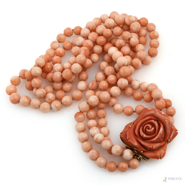 Collana in corallo pelle d'angelo a tre fili, con chiusura in oro 18 kt e centrale a guisa di rosa in corallo, peso lordo complessivo gr 221, lunghezza cm 60, (lievi segni di usura)