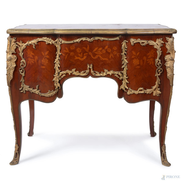 Scrivania in legno impiallacciato, intarsiato in varie essenze e decorato da inserti in bronzo do...