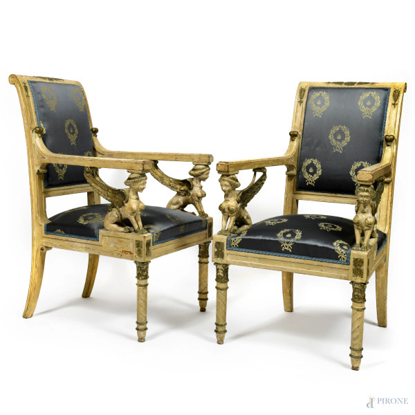 Coppia di poltrone in legno intagliato e laccato con seduta raccordata ai braccioli da sfingi alate. Seduta e schienale rivestiti in tessuto nei toni del blu e panna. XIX secolo, cm 98x57x63, (segni di usura, scalfiture, difetti, graffi)
