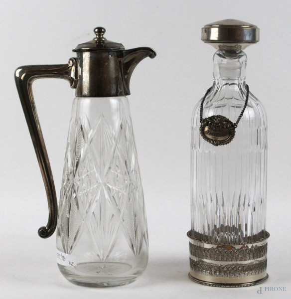 Una caraffa ed una bottiglia in cristallo controtagliato con finiture in argento e metallo argentato, altezza max cm. 30, XX secolo.