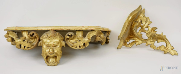 Lotto di due mensole in legno scolpito, dorato e laccato, XX secolo, decori di mascherone e volute, misure max cm 14x42x23, (difetti)