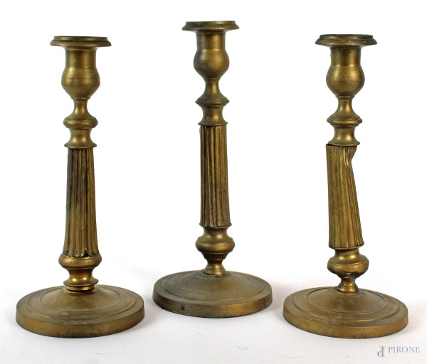 Lotto di tre candelieri in bronzo, fusti scanalati, basi circolari, altezza max cm 25, XIX secolo, (difetti)