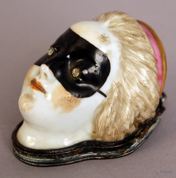 Cofanetto in porcellana a forma di volto in maschera, con occhi in zirconi e finiture in metallo, XIX sec. H.5x7x5.4cm.