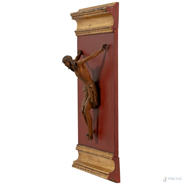 Crocifisso, XX secolo, scultura in legno fissata su pannello ligneo dorato e laccato, altezza cm ...