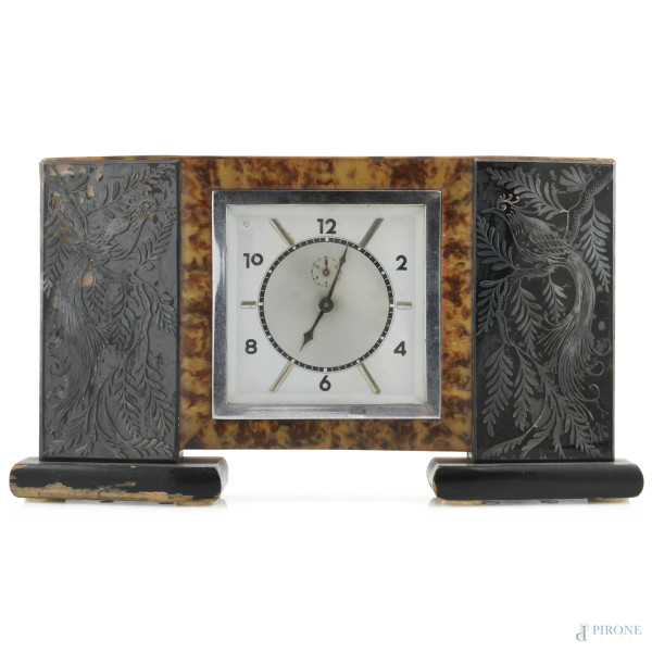 Orologio Decò da tavolo con struttura rivestita in finta tartaruga e decori argentati a guisa di pavoni tra gli alberi, XX secolo, cm 20x35, (segni di usura, scalfiture, difetti, da revisionare)