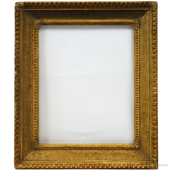 Cornice in legno intagliato e dorato, XIX secolo, profilo esterno dentellato, battuta interna perlinata, misure ingombro cm 58,5x69,5 misure luce cm 44x53, (difetti)