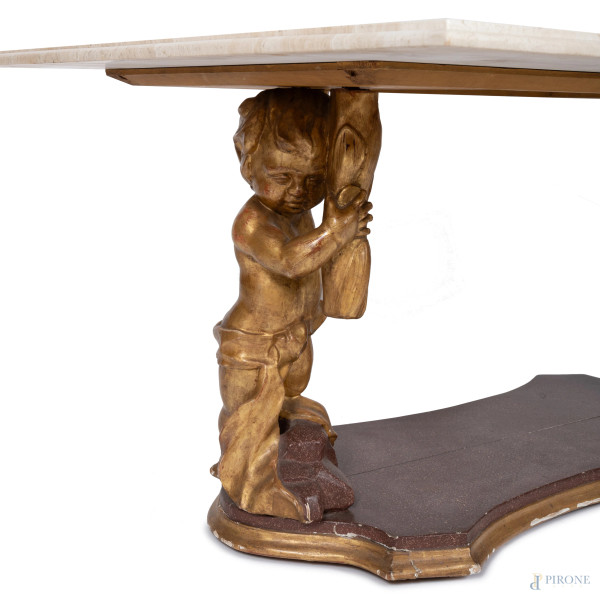 Tavolino basso con piano in marmo sorretto da sculture di putti in legno dorato su pedana sagomat...