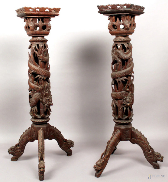 Coppia di colonne in tek a tutto intaglio di draghi, poggianti su tre piedi a forma di draghi, H 107 cm, (mancanze).